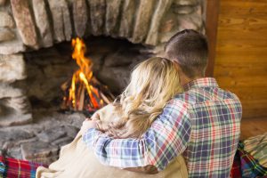 Couple-cuddling-in-front-of-the-fireplace-at-one-of-our-Gatlinburg-winter-cabins